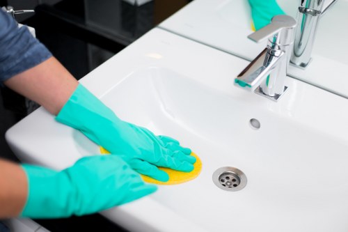 Local cleaner carrying out kitchen and bathroom cleaning in Barnes